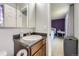Bathroom featuring a vanity, mirror, and an open doorway to a bedroom with purple walls at 10890 Stuart Ct, Westminster, CO 80031