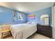 Comfortable bedroom features light blue walls, a window with curtains, and a bed with white linens at 10890 Stuart Ct, Westminster, CO 80031