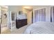 Comfortable bedroom with neutral walls, carpet, a full-length mirror, and a view of the en suite bathroom at 10890 Stuart Ct, Westminster, CO 80031
