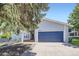 Charming light blue home featuring a blue garage door, covered porch, and well-maintained landscaping at 10890 Stuart Ct, Westminster, CO 80031