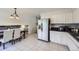 Bright eat-in kitchen featuring white cabinets, tile floors, stainless steel refrigerator, and a view of the adjacent dining area at 10890 Stuart Ct, Westminster, CO 80031