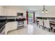 Bright eat-in kitchen features stainless steel appliances, white cabinets, a tile backsplash, and sliding glass doors to the deck at 10890 Stuart Ct, Westminster, CO 80031