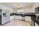 Modern kitchen with white cabinets, stainless steel appliances, and sleek black countertops at 10890 Stuart Ct, Westminster, CO 80031