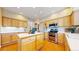 Bright kitchen offers wooden cabinets, an island, stainless steel appliances, and wood floors at 5640 S Marshall St, Denver, CO 80123