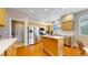 Bright kitchen features stainless steel appliances, island, wooden cabinets, and wood floors at 5640 S Marshall St, Denver, CO 80123