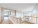 Upper level landing with white railing overlooking living space below at 5640 S Marshall St, Denver, CO 80123