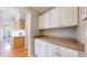 Butler's pantry with white cabinets and countertops, and door into kitchen at 5640 S Marshall St, Denver, CO 80123