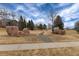 A well maintained community park with walking path, mature trees and decorative boulders at 14669 Eagle River Run, Broomfield, CO 80023