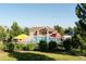 Fenced community pool with shade umbrellas and lounge chairs, surrounded by lush landscaping at 14669 Eagle River Run, Broomfield, CO 80023