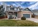 Two-story home with stone accents and a covered porch, set in a well-maintained yard at 14669 Eagle River Run, Broomfield, CO 80023