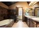Well-appointed bathroom with tile accents, a soaking tub, a double vanity, and modern lighting at 7955 S Bemis St, Littleton, CO 80120