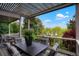 Inviting outdoor deck with a pergola covering a dining table surrounded by comfortable cushioned chairs at 7955 S Bemis St, Littleton, CO 80120