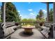 Outdoor deck featuring a fire pit, bench seating, and lovely views of the lush surroundings at 7955 S Bemis St, Littleton, CO 80120
