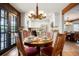 Dining area with round wooden table, decorative lighting, and bright kitchen in the background at 7955 S Bemis St, Littleton, CO 80120