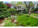 Landscaped front yard with a variety of plants, trees, and rocks creating a serene outdoor setting at 7955 S Bemis St, Littleton, CO 80120