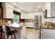 Bright kitchen with white cabinets, stainless steel appliances, granite countertops, and tile flooring at 7955 S Bemis St, Littleton, CO 80120