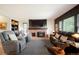 Cozy living room with a brick fireplace, built-in shelving, and comfortable leather seating at 7955 S Bemis St, Littleton, CO 80120