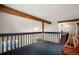 Carpeted loft area with wooden beams and railing overlooking the living space, adding architectural interest to the home at 7955 S Bemis St, Littleton, CO 80120