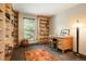 Well-lit home office featuring custom built-in shelving and a comfortable workspace with a neutral color palette at 7955 S Bemis St, Littleton, CO 80120