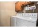 Laundry room featuring a side-by-side washer and dryer and overhead storage cabinets at 8600 E Alameda Ave # 21-208, Denver, CO 80247