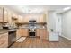 This spacious kitchen features stainless steel appliances, light wood cabinets, granite countertops, and warm wood flooring at 9625 E Center Ave # 5D, Denver, CO 80247