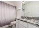 Full bathroom with granite vanity, toilet, shower and decorative curtain at 4602 Genoa St, Denver, CO 80249