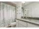 Bathroom featuring vanity, sink, mirror, shelving and a shower/tub with curtain at 4602 Genoa St, Denver, CO 80249