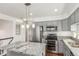 Modern kitchen with stainless steel appliances, gray cabinets, and granite countertops at 4602 Genoa St, Denver, CO 80249