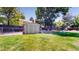 Spacious backyard featuring a shed, a deck, a swing set, mature trees and green grass at 982 E 130Th Cir, Thornton, CO 80241