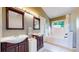Bathroom with double vanity sinks, a bathtub, shower with tile, and natural light creating a spa-like atmosphere at 982 E 130Th Cir, Thornton, CO 80241