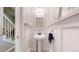 Charming powder room with a pedestal sink, decorative mirror, and wainscoting, complemented by a staircase in the background at 982 E 130Th Cir, Thornton, CO 80241