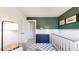 This well-lit Bedroom is designed with a blue and white rug, white crib, and a dark blue dresser at 982 E 130Th Cir, Thornton, CO 80241