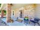 Welcoming front porch featuring brick pillars, vibrant flowers, and comfortable seating for visitors at 982 E 130Th Cir, Thornton, CO 80241