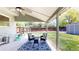 Relaxing covered patio with a seating area overlooking the backyard and mature trees and landscaping at 982 E 130Th Cir, Thornton, CO 80241