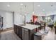 Bright and modern kitchen with stainless steel appliances, an island, and open access to the dining and living areas at 9679 Waco St, Commerce City, CO 80022