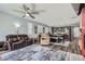 Open-concept living room featuring wood floors, a ceiling fan, a large area rug, and lots of natural light at 9679 Waco St, Commerce City, CO 80022