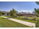 Street view of a sidewalk, grassy yards, wood fencing, and mature trees in a residential neighborhood at 9679 Waco St, Commerce City, CO 80022