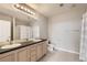 Bright bathroom with double sinks, vanity storage, and tiled floors at 15475 Andrews Dr # 401, Denver, CO 80239
