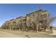 Beautiful brick apartment building with balconies and street view on a sunny day at 15475 Andrews Dr # 401, Denver, CO 80239