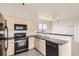 Bright kitchen with black appliances, light cabinets, and stylish countertops at 15475 Andrews Dr # 401, Denver, CO 80239