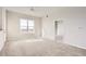 Well-lit living room featuring neutral paint, plush carpeting, and a large window showcasing the city view at 15475 Andrews Dr # 401, Denver, CO 80239