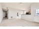 Spacious living room featuring neutral paint, plush carpeting, and access to a kitchen and entry way at 15475 Andrews Dr # 401, Denver, CO 80239