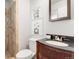 Bathroom featuring a dark vanity, modern fixtures, decorative artwork, and tiled walk-in shower at 602 Birch St, Broomfield, CO 80020