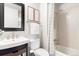 Bathroom with white vanity, framed mirror, and a shower-tub combination with bright tile at 602 Birch St, Broomfield, CO 80020