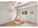 Bedroom space featuring a decorative teepee, soft rug, and window view to the outdoors at 602 Birch St, Broomfield, CO 80020
