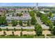 Charming street view of townhomes with colorful facades and manicured trees; Solar panels adorn the roofs at 8189 E 29Th Ave, Denver, CO 80238