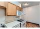 Efficient kitchen featuring wood cabinets, white appliances, and durable countertops at 2225 Buchtel Blvd # 105, Denver, CO 80210