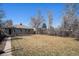 Brick home featuring a large backyard with a fence and mature trees at 1654 Valentia St, Denver, CO 80220