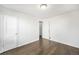 Bright bedroom with hardwood floors and white walls with several doors and a view into a hallway at 1654 Valentia St, Denver, CO 80220