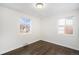 Comfortable bedroom with hardwood floors, white walls, and windows offering ample natural light at 1654 Valentia St, Denver, CO 80220